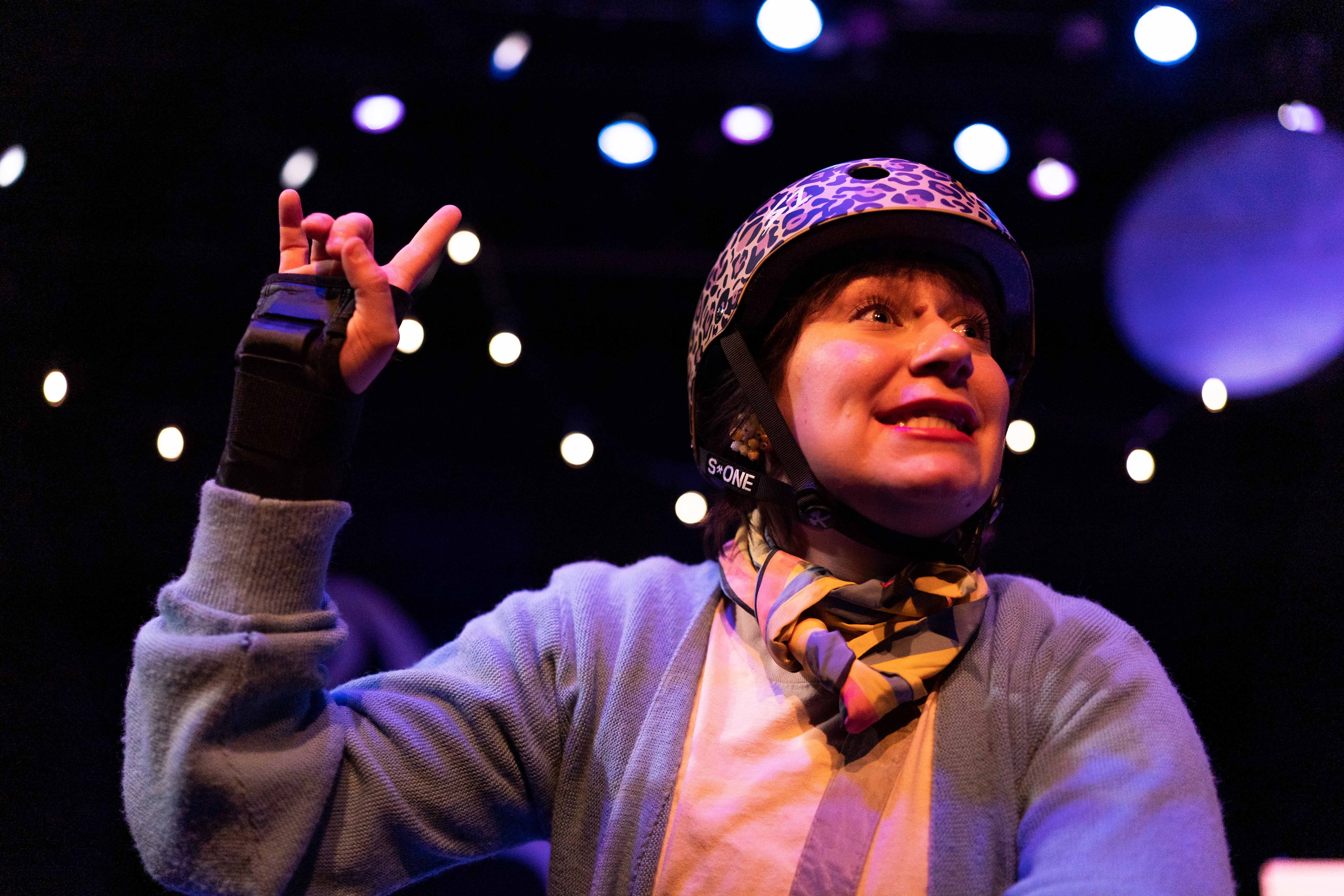 Close up on actress wearing leopard print helmet and a wrist brace