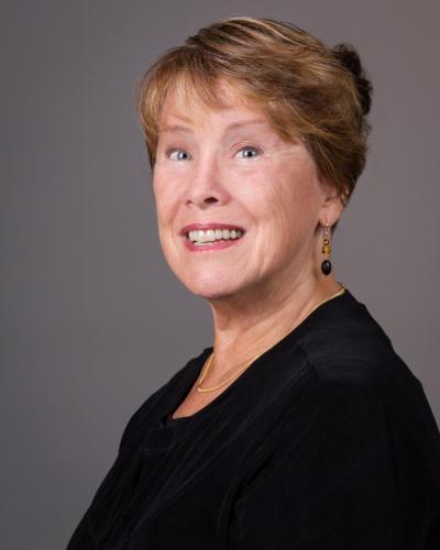 Headshot of woman in black shirt with short light brown hair