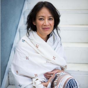 Picture of Sayda Trujillo wrapped in shawl sitting on steps